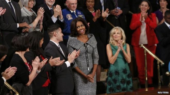 Мишель Обама реагирует на приветствия аудитории, когда она посещает выступление президента США Барака Обамы по вопросу о положении дел в Союзе