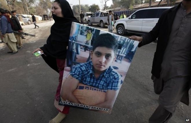 Пакистанская мать несет фотографию своего сына, который был убит во время нападения талибов 14 января.