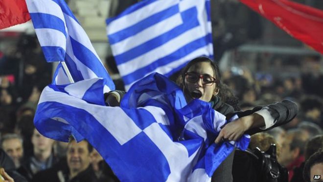 Толпа празднует победу Syriza в Греции, размахивая флагами