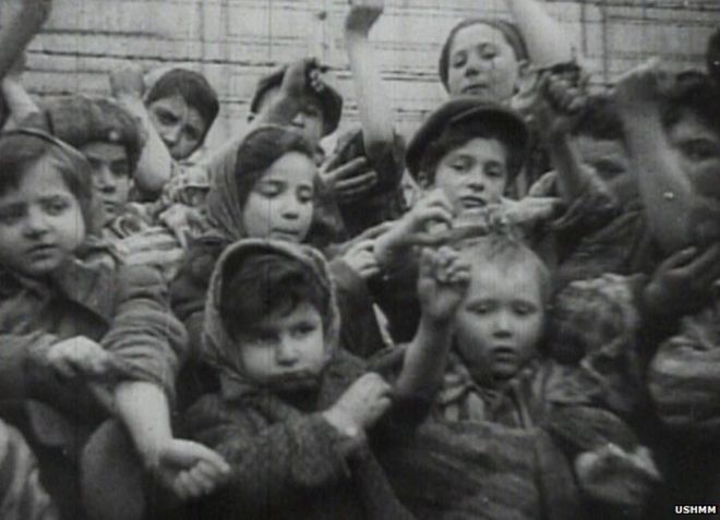 Дети в Освенциме показывают идентификационные номера, напечатанные на их руках