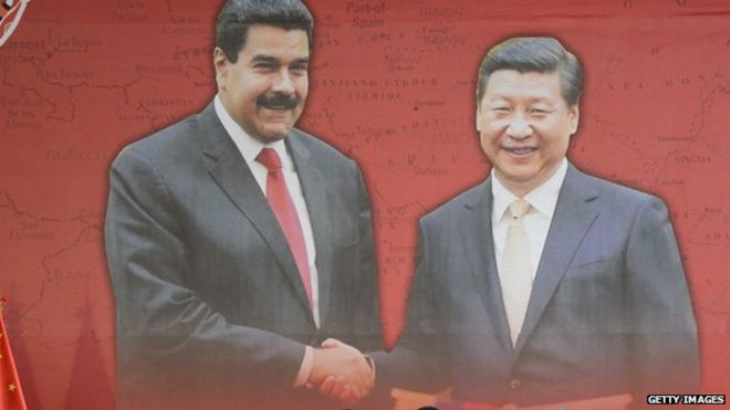 На плакате изображен президент Венесуэлы Николас Мадуро, пожимающий руку президенту Китая Си Цзиньпину во время церемонии подписания соглашений в Каракасе 21 июля 2014 года.