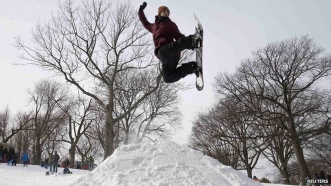 Мейсон Глудеман, 26 лет, использует сноуборд, чтобы спрыгнуть с кучи снега в парке Форт-Грин в Бруклине после снежной бури в Нью-Йорке 27 января 2015 года.