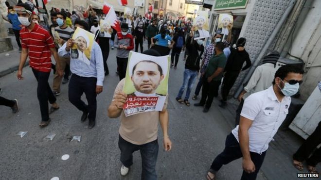 Протестующие несут фотографии главного лидера оппозиции Бахрейна Али Салмана, когда они маршируют по соседству с его домом во время акции протеста в деревне Билад аль-Кадим к югу от Манамы (30 января 2015 года)