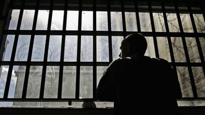 Заключенный смотрит из тюрьмы