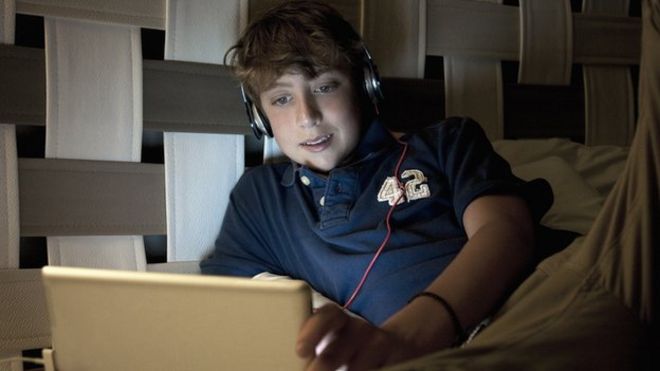 подросток, использующий ноутбук