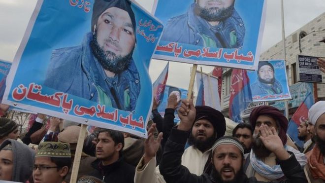 Пакистанский исламист и сторонники бывшего полицейского телохранителя Мумтаза Кадри держат его портрет, выкрикивая лозунги, призывающие его освободить во время акции протеста возле здания Верховного суда в Исламабаде 3 февраля 2015 года.