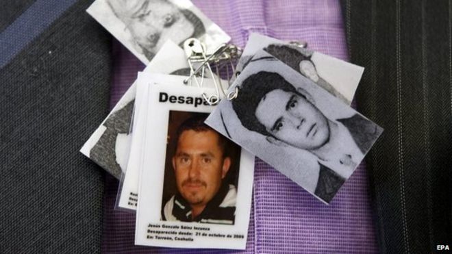 Член НПО носит фотографии пропавших людей в Мексике во время заседания Комитета ООН по насильственным исчезновениям в Женеве 2 февраля 2015 года.