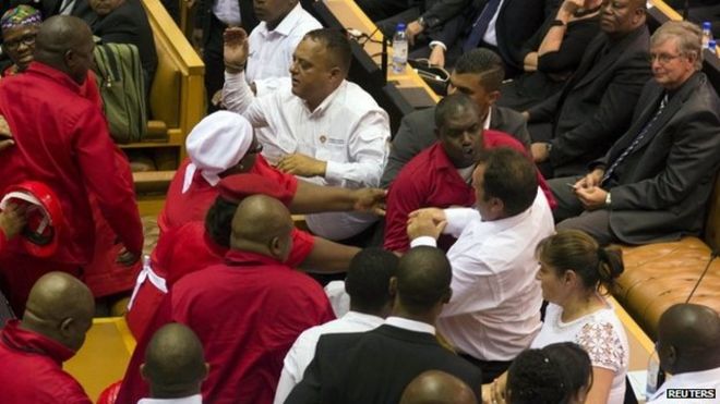 Драки депутатов EFF в красной рубашке с белыми рубашками силовиков в парламенте ЮАР