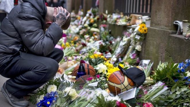 Мужчина скорбит рядом с цветами возле синагоги в Копенгагене 16.02.2015