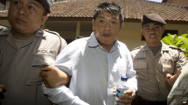 На этой фотографии 21 сентября 2010 года Эндрю Чана сопровождают индонезийские полицейские в окружном суде Денпасара перед началом слушания
