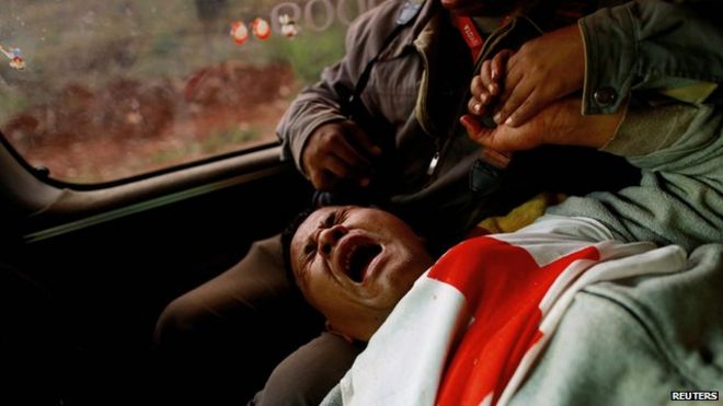 Мо Че Тхан, 45 лет, волонтер из Общества Красного Креста Мьянмы, реагирует после того, как он был ранен, когда его колонна была обстреляна 17 февраля 2015 года