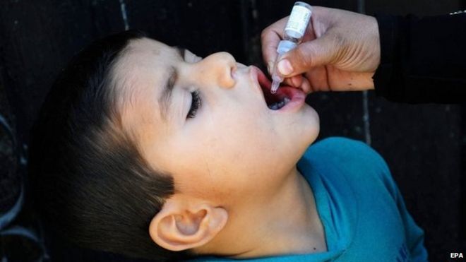 Медицинский работник вводит вакцину против полиомиелита ребенку в Карачи, Пакистан, 27 января 2015 года.