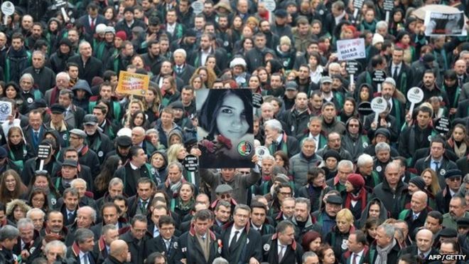 Мужчина держит плакат с изображением убитого Озгекана Аслана во время марша членов Ассоциации адвокатов Турции в Анкаре 16 февраля 2015 года