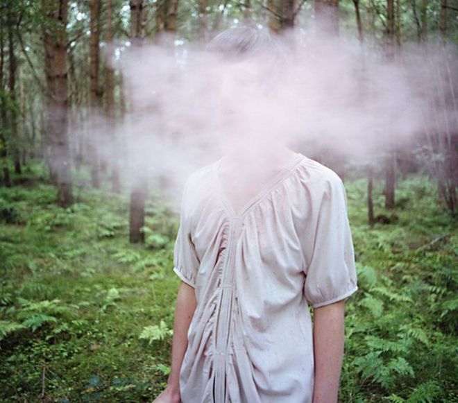 Женщина в лесу, ее лицо полностью покрыто туманом