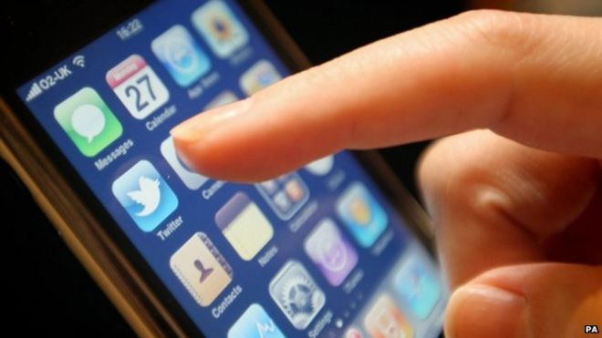 Finger указывает на приложение Twitter на iPhone