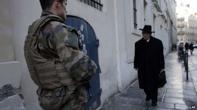 Солдаты патрулируют улицу в Париже в январе после того, как 10 000 военнослужащих были мобилизованы для защиты чувствительных мест - почти половина из них охраняла еврейские школы