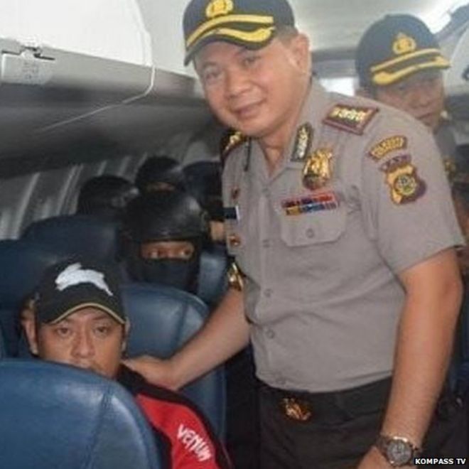 Индонезийский полицейский Джоко Хари Утомо позирует с Эндрю Ча, улыбаясь
