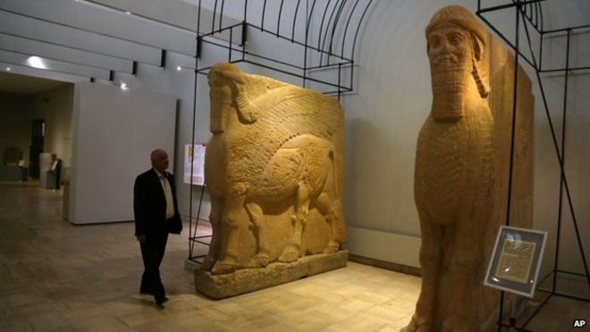 Мужчина проходит мимо двух древних ассирийских статуй крылатых быков в Национальном музее Ирака в Багдаде 1 марта 2015 года
