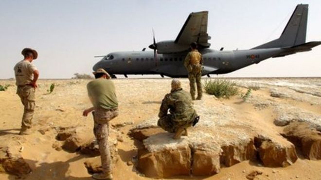 Американские тренеры и чадские солдаты рядом с военным самолетом