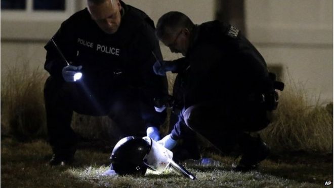 Полиция осматривает шлем, лежащий на земле после того, как два офицера были застрелены в Фергюсоне, штат Миссури, 12 марта 2015 года
