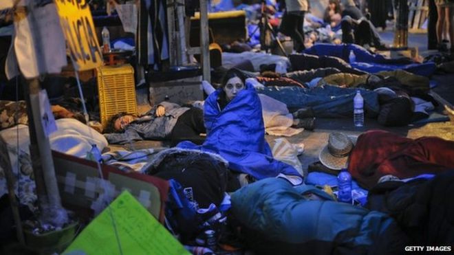 Демонстрант наблюдает за тем, как она проводит ночь в лагере Сол-сквер во время продолжающейся акции протеста 22 мая 2011 года в Мадриде, Испания