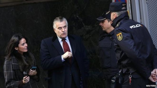 Луис Барсенас (С), бывший казначей правящей Народной партии Испании (ПП), беседует с полицейскими по прибытии в Высокий суд Испании 23 января 2015 года