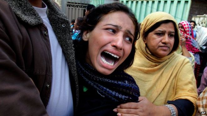 Женщина оплакивает члена семьи, погибшего в результате взрыва смертника