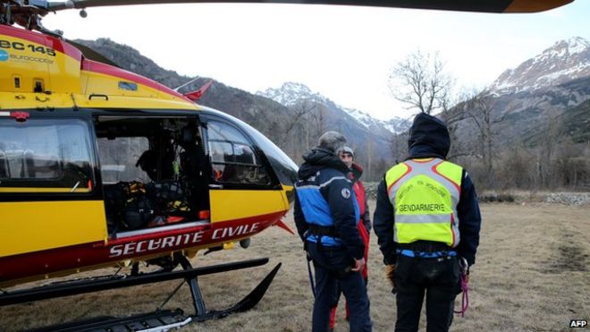 French gendarmes and rescuers stand near a helicopter on April 1, 2015 in Vallouise, in the French Alps