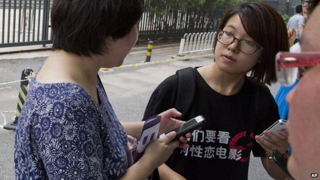 Снимок сделан 31 июля 2014 года, на нем активист Вэй Тинтинг (справа) перед судом