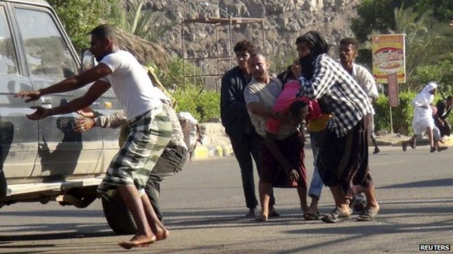 People carry a man injured during a gunfire at an army base in Yemen's southern port city of Aden 25 March 2015.