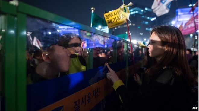 Протестующие и родственники жертв столкновения на пароме в Сьюоле с полицией, которые пытаются пройти к президентскому Голубому дому в Сеуле 11 апреля 2015 года