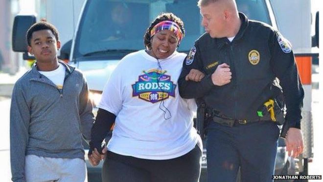 Полицейский помогает женщине во время пробега на 10 км