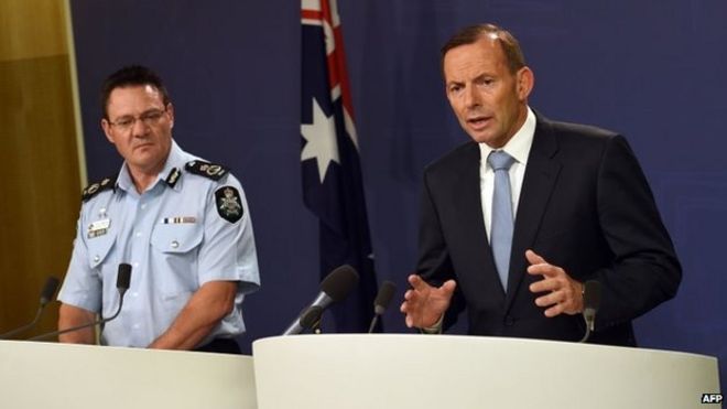Премьер-министр Австралии Тони Эбботт (справа) беседует с представителями средств массовой информации во время слушания заместителя комиссара Федеральной полиции Австралии Майкла Фелана (слева) в Сиднее, 18 апреля 2015 года