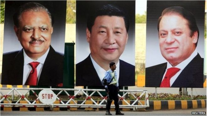 Полицейский стоит на страже рядом с гигантскими портретами президента Пакистана Мамнуна Хуссейна (слева направо), президента Китая Си Цзиньпина и премьер-министра Пакистана Наваза Шарифа в Пакистане (19 апреля 2015 г.)