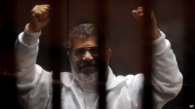Мохаммед Мурси жесты на скамье подсудимых в зале суда в Каире, Египет (3 марта 2015 года)