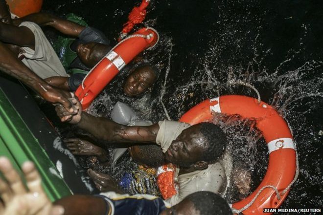 Африканские мигранты, в том числе Иса и Ибрагим из Мали, пытаются подняться на борт испанской гражданской гвардии после того, как их лодка перевернулась