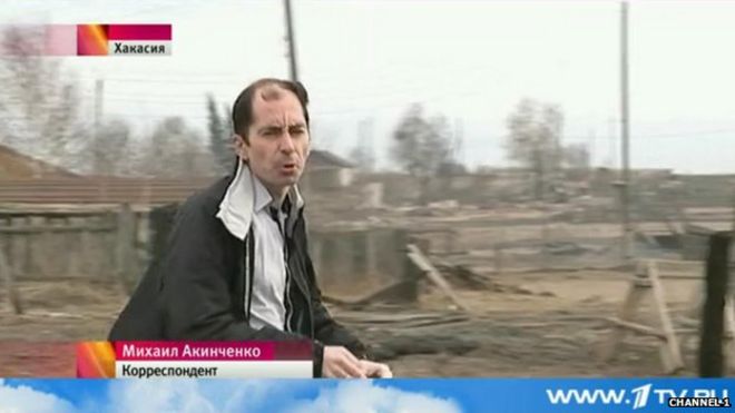 Российский журналист Михаил Акинченко делает снимок на камеру в видеорепортаже о лесных пожарах в российской республике Хакасия в апреле 2015 года