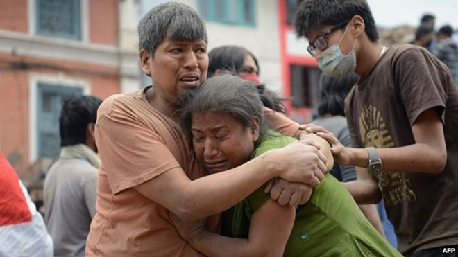 Непальский мужчина и женщина обнимаются на площади Дурбар в Катманду, объекте Всемирного наследия ЮНЕСКО, который был серьезно поврежден в результате землетрясения 25 апреля 2015 года
