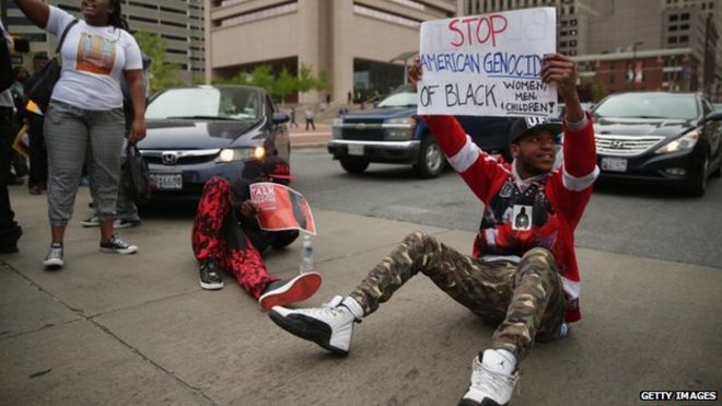 Протестующие блокируют движение во время марша в честь Фредди Грея 25 апреля 2015 года в Балтиморе, штат Мэриленд. Грей, 25 лет