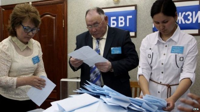 Члены местной избирательной комиссии опорожняют урну для голосования после закрытия избирательных участков на президентских выборах в Астане (26 апреля 2015 года)