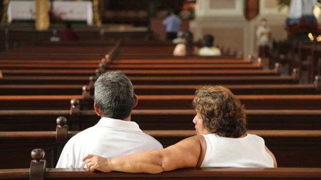 Люди сидят на скамье в соборе в Сальвадоре