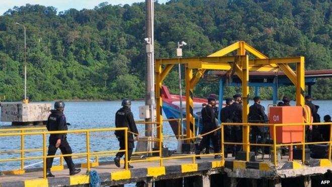 Расстрел индонезийской полиции садится на лодку к острову, где были казнены мужчины