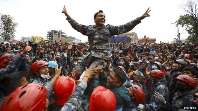 Члены Вооруженных сил Непала приветствуют после успешного спасения выжившего после землетрясения 15-летнего Пема Ламы из разрушенного отеля Hilton в Катманду, Непал (30 апреля 2015 года)