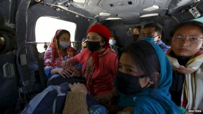 Жертвы землетрясения, доставленные по воздуху из района Синдхупалчок, садятся в армейский вертолет на пути в Катманду