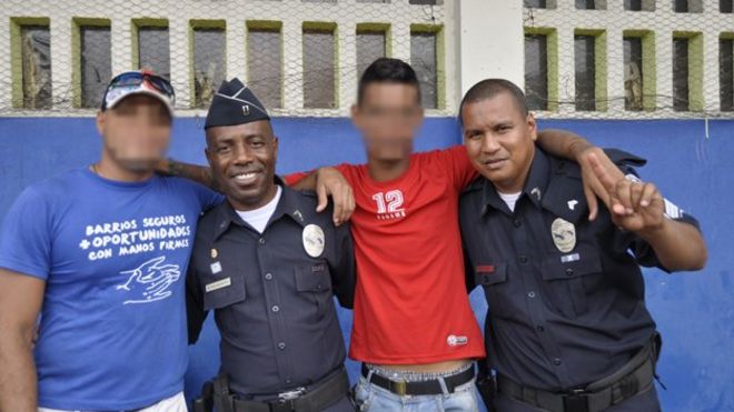 Двое полицейских позируют с двумя бывшими членами банды в Сан-Мигелито