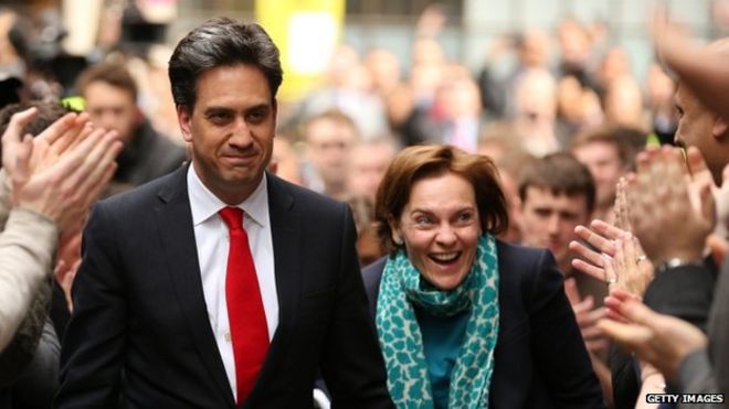 Эд Милибэнд машет рукой, когда он прибывает со своей женой Джастин Торнтон в штаб-квартиру лейбористской партии 8 мая 2015 года