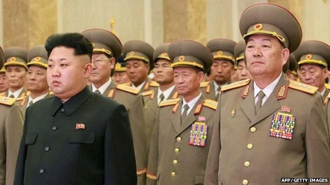 На этом снимке, сделанном 16 февраля 2015 года, изображен министр обороны Северной Кореи Хён Йон Чхоль (справа), стоящий с северокорейским лидером Ким Чен Уном (передний край L) во дворце Кумсусан в Пхеньяне