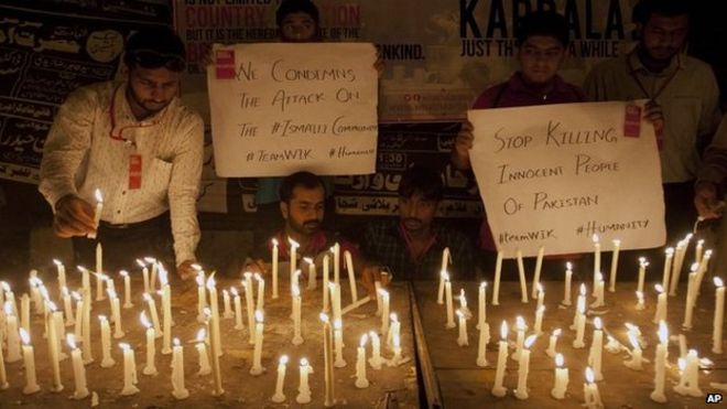 Люди зажигают свечи в знак протеста и выражают солидарность с жертвами автобусной атаки в Карачи, Пакистан, в среду, 13 мая 2015 года.