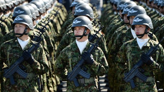 Японские солдаты слушают премьер-министра Синдзо Абэ во время военного обзора на полигоне Асака Сухопутных сил самообороны 27 октября 2013 года.