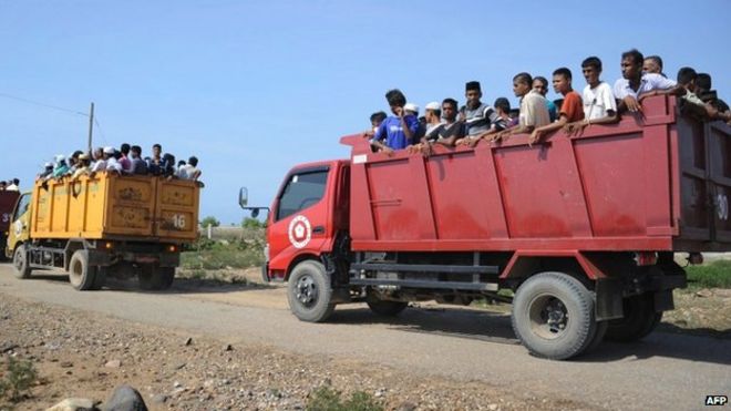 Спасенные мигранты, в основном рохинги из Мьянмы и Бангладеш, перевозятся на грузовиках в рыбацкий город Куала Чанкой в ??провинции Ачех, Индонезия (13 мая 2015 года)